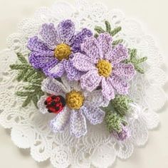 crocheted doily with flowers and ladybug on it