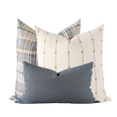 two pillows sitting next to each other on top of a white flooring area with blue and brown plaid pillow cases