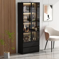 a black cabinet with glass doors in a living room next to a chair and potted plant