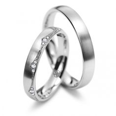 two white gold wedding rings with diamonds on each one and the other in between them