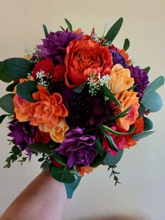 a bridal bouquet with orange and purple flowers