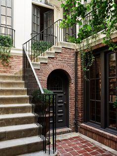 an entrance to a brick building with wrought iron railings and steps leading up to the door