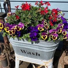 an old wheelbarrow with flowers in it