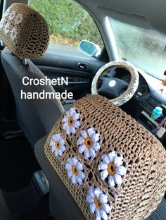 the interior of a car with crochet and flowers on the front seat cover