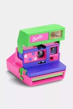 a toy polaroid camera sitting on top of a pink and green box