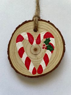 a wooden ornament with candy canes and holly