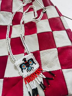 the beaded necklace is decorated with an image of a cat on red and white checkered fabric