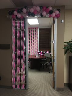 an office decorated with pink, black and white balloons