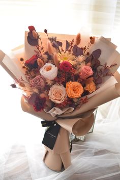 a bouquet of flowers is wrapped in brown paper