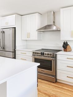 White kitchen with white cabinets and gold accents. Stainless steel kitchen appliances White And Gold Kitchen Stainless Steel Appliances, Small White Kitchen Gold Hardware, Kitchen Decor With Stainless Steel Appliances, Stainless Steel Appliances With White Cabinets, Stainless Steel Farmhouse Sink With Gold Hardware, White Kitchen Stainless Steel Appliances, Kitchen With Gold Hardware And Stainless Appliances, Brass Kitchen Hardware With Stainless Steel Appliances, Stainless Steel Appliances With Brass Hardware