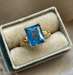 Beautiful rich blue gemstone vintage ring. The color of the blue is absolutely dazzling! The ring dates to the 1940s - 1960s approximately.  Solid 10K yellow gold. Emerald cut gemstone tests as topaz on my at-home SmartPro Gem Tester but looks more like it could be blue spinel, especially judging by the older setting and the high hardness rating. I am not a Gemologist.  Signed and tested real 10K gold. Size 5 US; resizable by your local jeweler.  Measures 10 mm tall, see all photos. Main photo is enlarged/zoomed-in to show you details. In great used, vintage pre-owned condition. Slight rattle when shaken but the stone is secure and in lovely condition for its age. Light normal patina/wear to mount.  See you on Instagram @luxcharmjewelry xo Collectible Blue 14k Gold Rings, Vintage Formal Birthstone Ring, Vintage Birthstone Ring For Formal Occasions, Vintage Gemstone Birthstone Ring For Formal Occasions, Collectible Vintage Sapphire Ring, Blue 14k Gold Birthstone Ring, Blue 14k Gold Hallmarked Birthstone Ring, Vintage 14k Gold Emerald Ring With Center Stone, Blue Emerald Classic Promise Ring