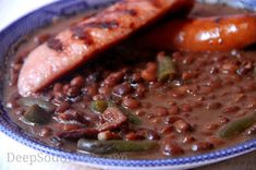 two sausages and beans in a bowl on a table