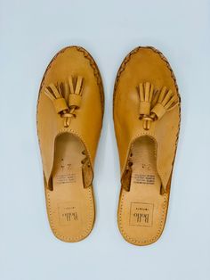 The quality of leather on these backless loafers is amazing! They also have a sturdy sole, which allows you to wear them for longer periods of time. A clean look with fun tassels and woven side, it is simple yet stunning. Genuine leather Tan & Black Handmade in Mexico ﻿Pro-tip! The front of this loafer opens up nicely once worn in and is perfect for a wider foot. Casual Leather Slippers With Woven Sole, Casual Slip-on Tassel Loafers With Closed Toe, Casual Slip-on Loafers With Tassels, Casual Tassel Slip-on Loafers, Beach Leather Loafers With Woven Sole, Summer Leather Tassel Loafers With Round Toe, Casual Brown Sandals With Tassels, Casual Woven Leather Clogs With Closed Toe, Leather Tassel Loafers With Round Toe For Summer