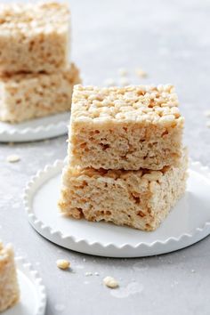 three pieces of rice krispy treats stacked on top of each other in small white plates