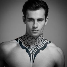 a man with tattoos on his chest and neck