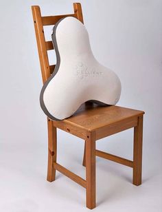 a wooden chair with a white and gray foot rest on it's back legs