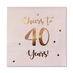 a white napkin with gold foil lettering that says cheers to 40 years