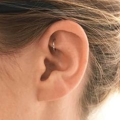 a woman's ear is shown with a single piercing