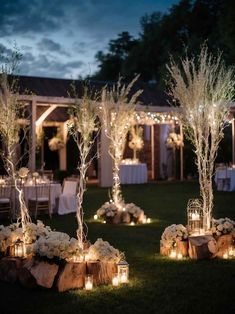 an outdoor setting with candles and flowers on the ground, surrounded by wooden stumps