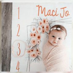 a baby wrapped in a blanket next to a flower arrangement with the numbers 1, 2, and 3