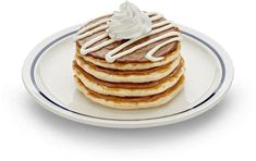 a stack of pancakes topped with whipped cream