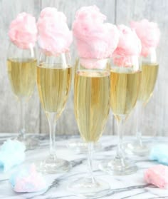 four champagne flutes filled with pink and white frosting