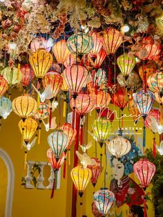 many colorful lanterns are hanging from the ceiling