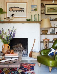 a living room filled with furniture and a fire place under a painting on the wall