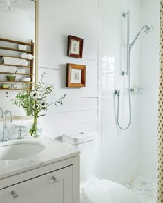 a bathroom with white walls and flooring has a shower, toilet, and sink