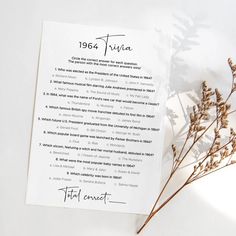 an open book with writing on it next to some dried flowers and leaves in the foreground