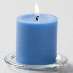 a blue candle sitting on top of a glass plate