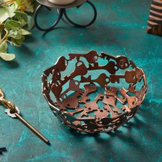 a metal bowl sitting on top of a green table next to scissors and other items