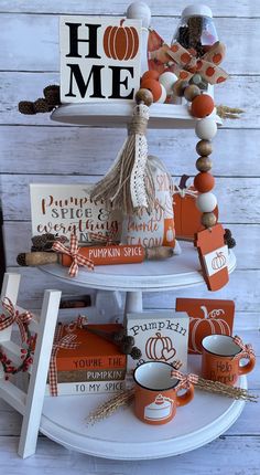 a three tiered display with pumpkins, books and other items on the shelves