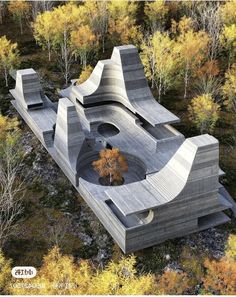 an aerial view of a concrete structure in the middle of trees with yellow leaves around it