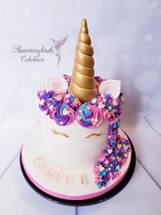 there is a cake that looks like a unicorn's head with flowers on it