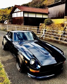 a black sports car parked in front of a house