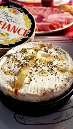 a pie sitting on top of a pan covered in cheese and toppings next to a container of ice cream