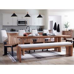 a wooden table with two benches in front of it and an open kitchen area behind it