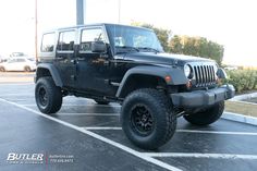 a black jeep parked in a parking lot