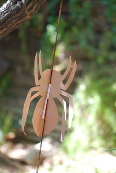 a paper spider hanging from a tree branch