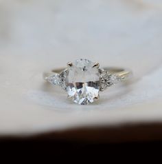 an oval cut diamond with three smaller diamonds on the side