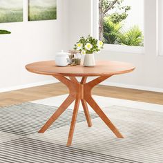 a wooden table with two vases on top of it in front of a window