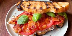 a grilled chicken sandwich with tomatoes and basil