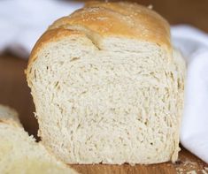 a loaf of white bread sitting on top of a wooden cutting board