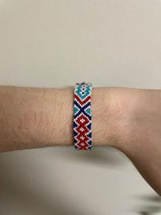 a man's arm with a bracelet made out of woven material and beading