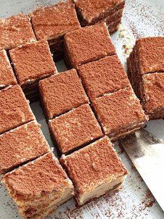 several pieces of brownie sitting on top of a white plate next to a knife