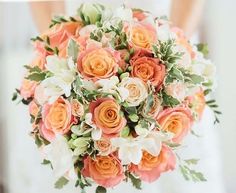 a bridal holding a bouquet of orange and white flowers