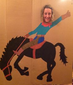 a woman standing next to a cardboard cutout of a horse and rider on it