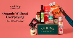 a woman holding up a box full of organic products with the words thive market on it