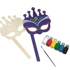 a purple mask and some paint sticks on a white background with the words mardi gras written below it